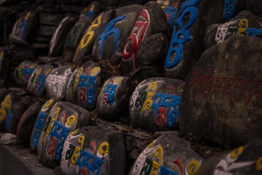 Religious colorful inscriptions in stones, Chame mountain village, trekking Annapurna circuit, Nepal