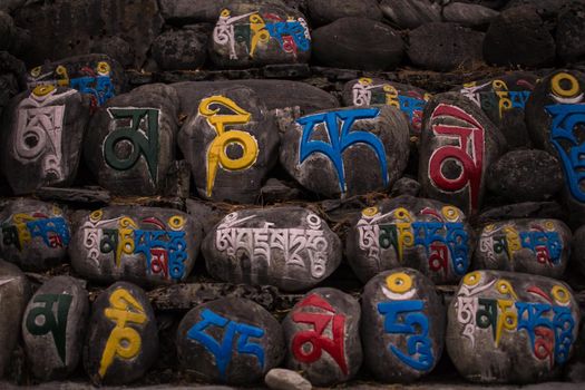 Religious colorful inscriptions in stones, Chame mountain village, trekking Annapurna circuit, Nepal