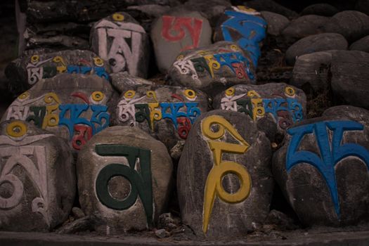 Religious colorful inscriptions in stones, Chame mountain village, trekking Annapurna circuit, Nepal