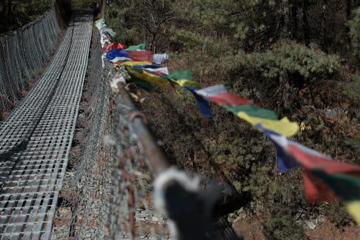 Trekking Annapurna circuit, suspension bridge with buddhist prayer flags over Marshyangdi river