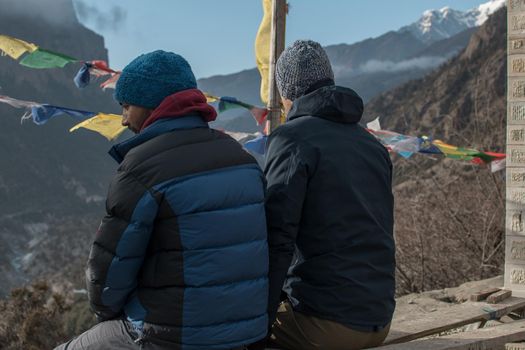 Two young hiker friends looking at the mountains over Lower Pisang, Annapurna circuit