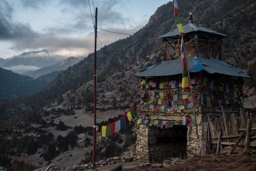 Colorful buddhist prayer flags stone monument, Upper Pisang, trekking Annapurna circuit, Himalaya, Nepal