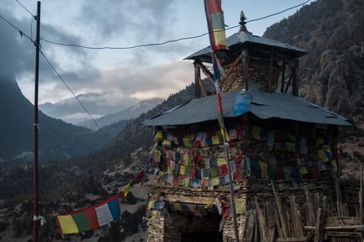 Colorful buddhist prayer flags stone monument, Upper Pisang, trekking Annapurna circuit, Himalaya, Nepal