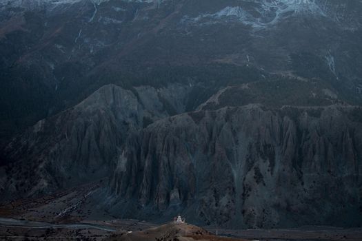 Buddhist stupa with prayer flags in front of massive mountain, trekking Annapurna circuit, Himalaya, Nepal