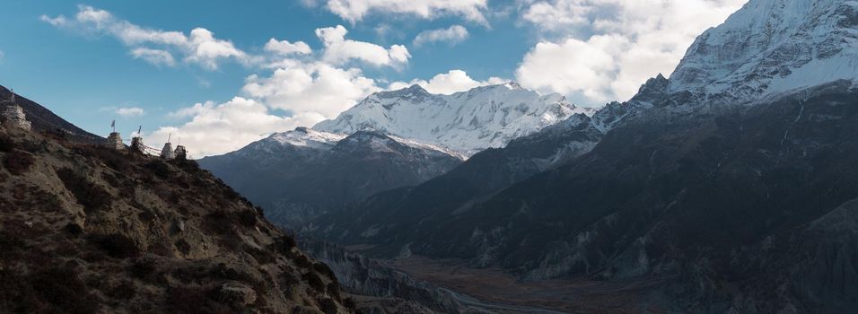 Panorama of buddhist stone monuments with prayer flags in the nepalese mountains, trekking Annapurna circuit