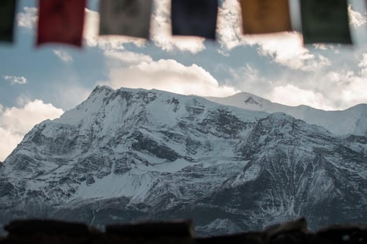 Buddhist prayer flags in the snowy nepalese mountains, Annapurna circuit, Himalaya