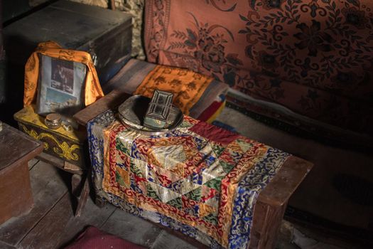 Colorful buddhist ornament mat and shrine on wooden bench