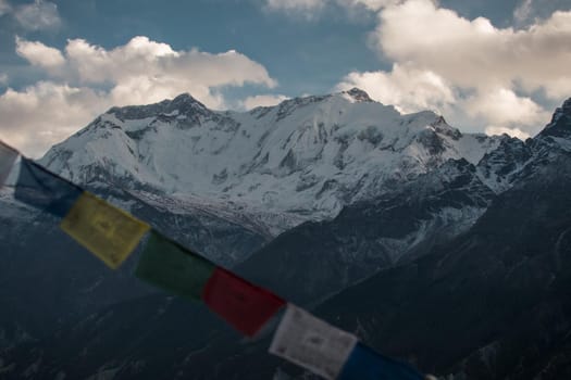 Buddhist prayer flags in the snowy nepalese mountains, Annapurna circuit, Himalaya
