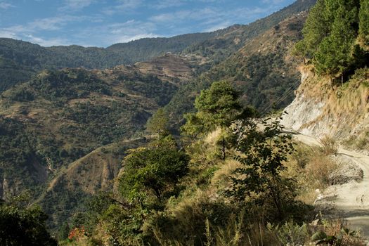 Dirt road going uphill at Annapurna circuit, Nepal with rolling hills in the background