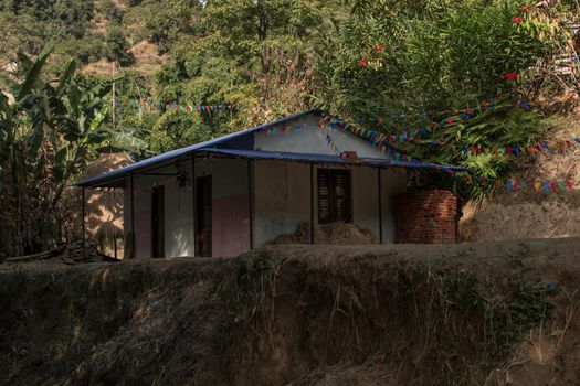 Buddhist praying flags attatched to a small house in a nepalese village, annapurna circuit