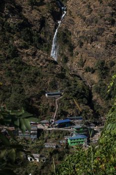 Waterfall flowing above a nepalese mountain village at Annapurna circuit