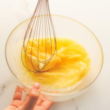 Cooking, meal and diet concept - Making of mixing eggs in bowl on marble table as homemade food flat lay, top view food brand photography flatlay and recipe for cooking blog, menu or cookbook design