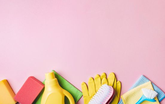 House cleaning product on pink background, copy space. Flat lay or top view. Cleaning service or housekeeping concept with space for text or design