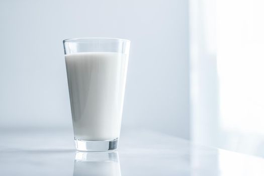 Dairy, healthy nutrition and breakfast concept - World Milk Day, full glass on marble table