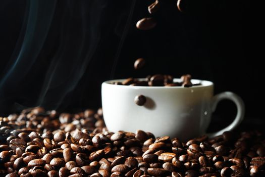 Coffee beans falling in black coffee cup, black background