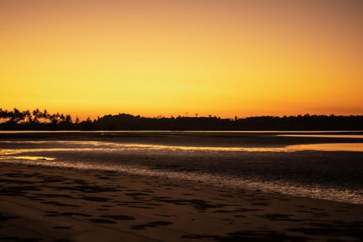 A sand beach during low tide and a bright orange sunset, peace and quiet, near Ngwesaung, Irrawaddy, western Myanmar