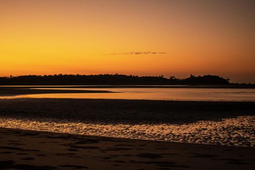 A sand beach during low tide and a bright orange sunset, peace and quiet, near Ngwesaung, Irrawaddy, western Myanmar