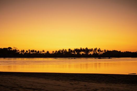 A sand beach during low tide and a bright orange sunset, peace and quiet, near Ngwesaung, Irrawaddy, western Myanmar