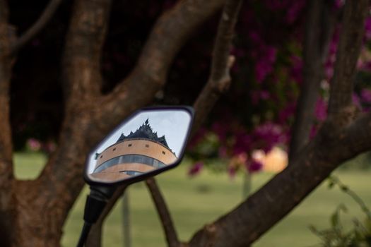 BAGAN, NYAUNG-U, MYANMAR - 3 JANUARY 2020: The top of Nan Myint viewing tower being reflected in the side mirror of a bicycle by a tree