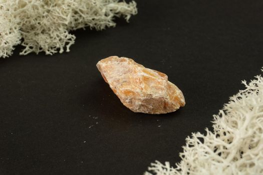 Orange Calcite from Brazil. Natural mineral stone on black background. Mineralogy, geology, magic of stones, semi-precious stones and samples of minerals. Close-up macro photo