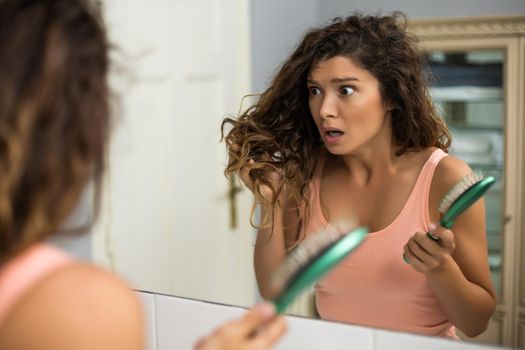 Beautiful woman in panic because of hair loss.