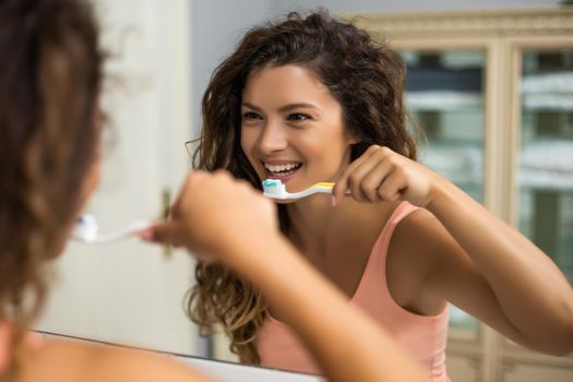 Beautiful woman brushing teeth in the bathroom.