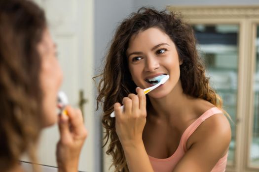 Beautiful woman brushing teeth in the bathroom.
