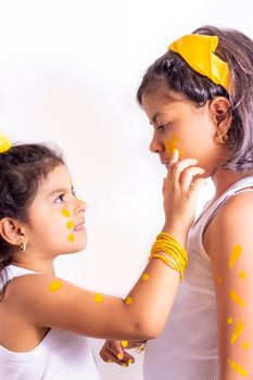 Two little girl, with her face painted to celebrate the yellow day