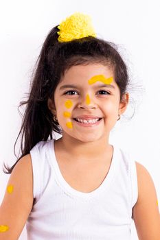 Happy little girl, with her face painted to celebrate the yellow day