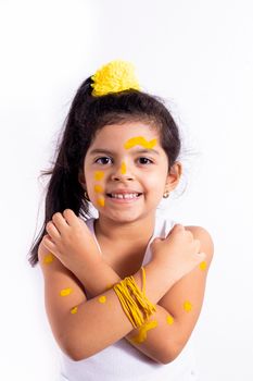 Happy little girl, with her face painted to celebrate the yellow day