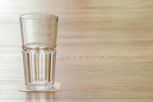 Closeup empty glass on wooden table, meaning a positive attitude towards something and prompt to learn anything