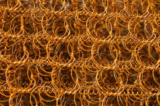 Closeup old and rusty bed coil spring, orange color rusted metal steel suspension for mattress
