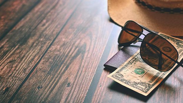 Items for summer vacation: a camera, passport,smartphone, money, hat, sunglasses. Wooden background, top view with Copy space. Beautiful summer concept for travel.