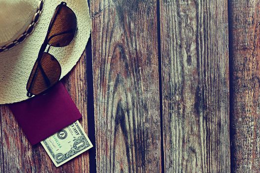 Items for summer vacation: a camera, passport,smartphone, money, hat, sunglasses. Wooden background, top view with Copy space. Beautiful summer concept for travel.