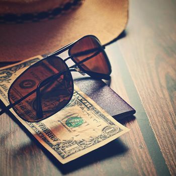 Items for summer vacation: a camera, passport,smartphone, money, hat, sunglasses. Wooden background, top view with Copy space. Beautiful summer concept for travel.