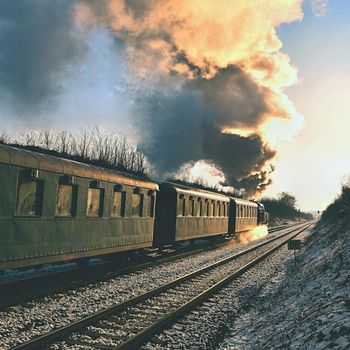 Beautiful old steam train with wagons running on rails at sunset. Excursions for children and parents on festive special days. Czech Republic Europe.