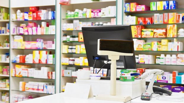 Cash desk - computer and monitor in a pharmacy. Interior of drug and vitamins shop. Medicines and vitamins for health and healthy lifestyle.  
