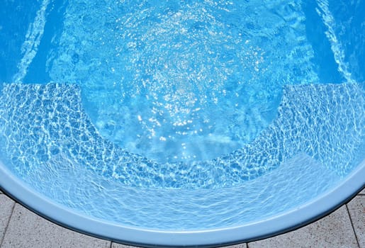 Ripple Water in swimming pool with sun reflection. Summer background for traveling and vacation. Holiday idyllic.