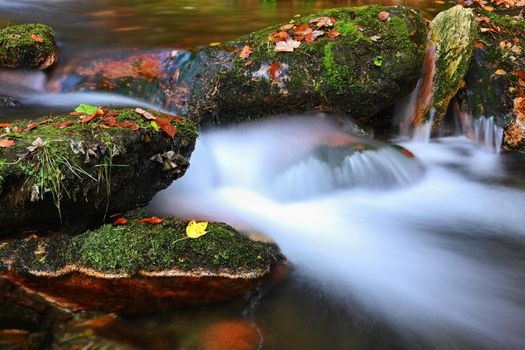 Beautiful colorful background with river and stones in autumn time. White Opava Waterfalls - Jeseniky Mountains - Czech Republic.