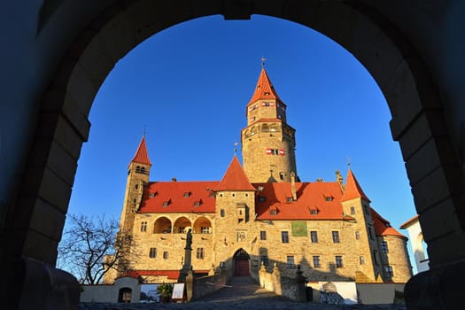 Beautiful old romantic Bouzov castle at sunset with autumn landscape.