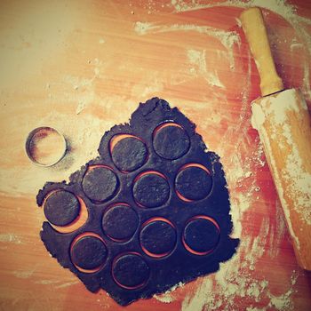 Baking Christmas cookies. On the table, flour, roller and dough.