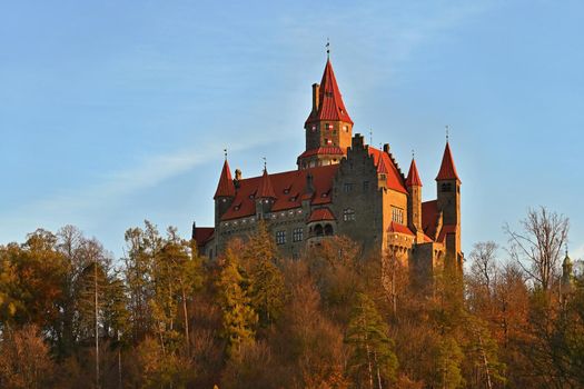 Beautiful old romantic Bouzov castle at sunset with autumn landscape.