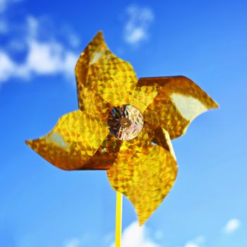 Beautiful yellow wind turbine - vane. Background with blue sky.