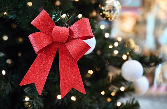 Beautiful Christmas ornament on the Christmas tree with lights. Red bows.