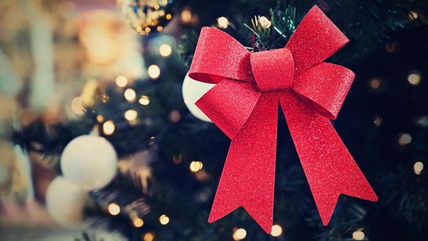 Beautiful Christmas ornament on the Christmas tree with lights. Red bows.