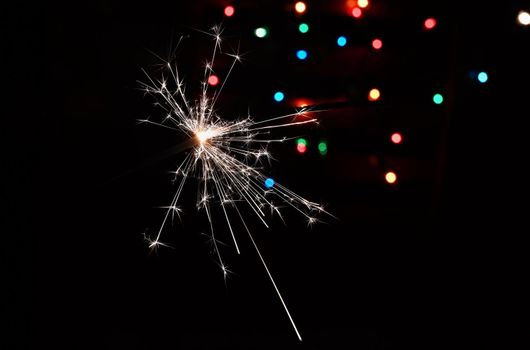 Beautiful Christmas - New Year background with sparkler and colorful lights.