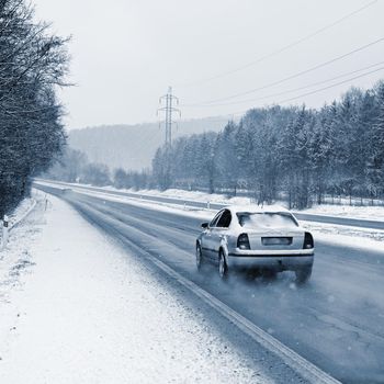 Cars on winter road with snow. Dangerous automobile traffic in bad weather.