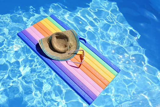 Sunglasses, lilo and hat on the water in hot sunny day. Summer background for traveling and vacation. Holiday idyllic.