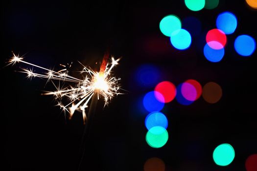 Concept for Christmas and Happy New Year.
Burning sparkler with beautiful color background.
