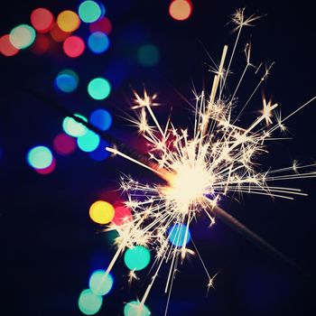 Concept for Christmas and Happy New Year.
Burning sparkler with beautiful color background.
